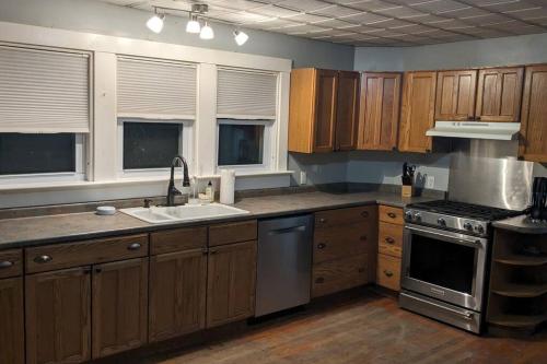 a kitchen with wooden cabinets and a sink and a stove at Bangor home minutes from airport in Bangor