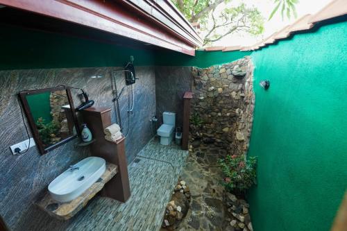 a bathroom with a sink and a mirror on a wall at Sigiri Close-up View Guest in Sigiriya