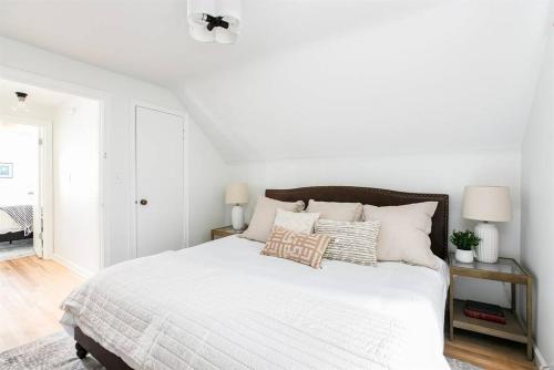 - une chambre blanche avec un grand lit blanc et des oreillers dans l'établissement Cozy and Freshly Updated 3BR Home Walking Distance, à South Bend