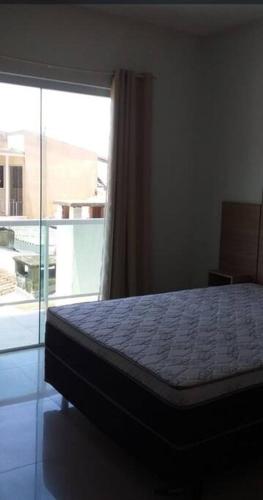 a bedroom with a bed and a large window at Sobrado duas quadras da praia in Guaratuba