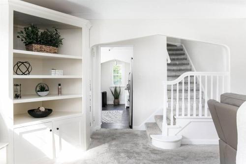 een witte trap in een woonkamer met witte muren bij The Stay Like a Champion Haven 4BR/3B 7min ND 12+ in South Bend
