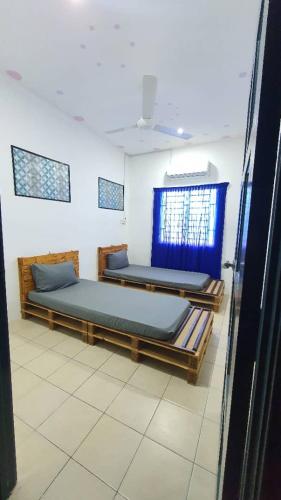 una camera con due letti e una finestra di Homestay Sri Indah 2 a Kampong Parit