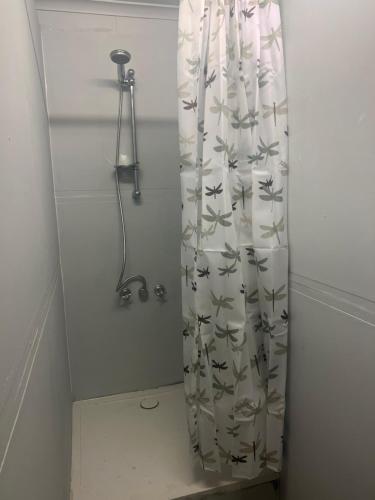 - un rideau de douche avec des oiseaux dans la salle de bains dans l'établissement Q Lux Inn Emerald, à Emerald