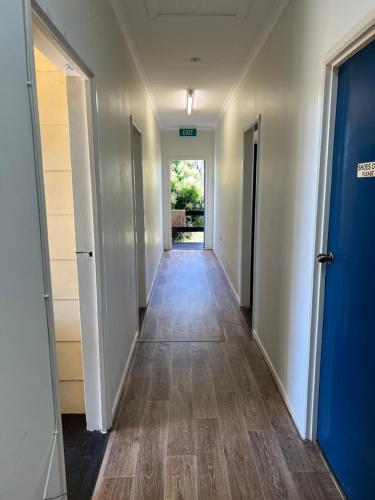 un corridoio di una stanza vuota con porta e pavimenti in legno di Q Lux Inn Emerald a Emerald