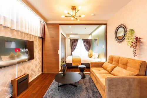 a living room with a couch and a bed at FDS Panache in Osaka