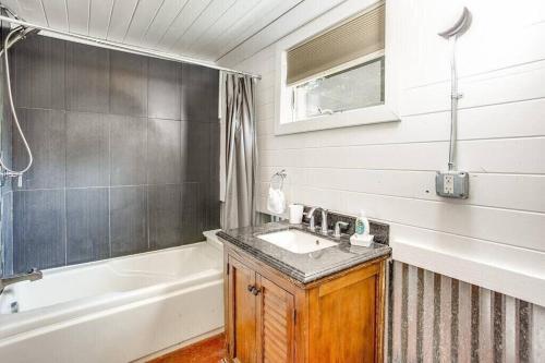 a bathroom with a sink and a bath tub at Cozy Tiny House Bungalow 7 Blocks from Campus in South Bend