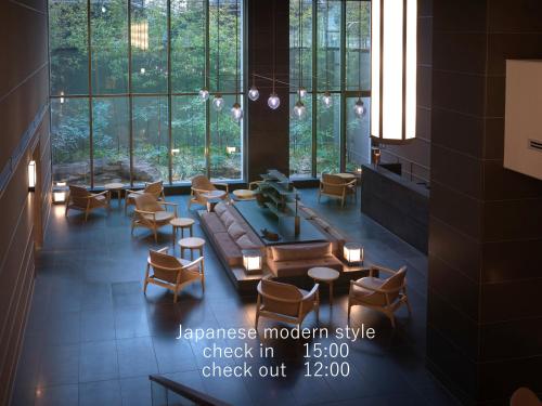 a lobby with a couch and chairs and windows at Hotel The Celestine Kyoto Gion in Kyoto