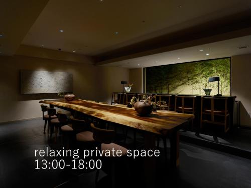 京都市にあるホテル ザ セレスティン京都祇園  の長い木製テーブルと椅子が備わる広い客室です。