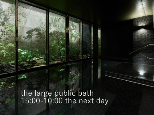 ein großes öffentliches Bad mit Wald durch Fenster gesehen in der Unterkunft Hotel The Celestine Kyoto Gion in Kyoto