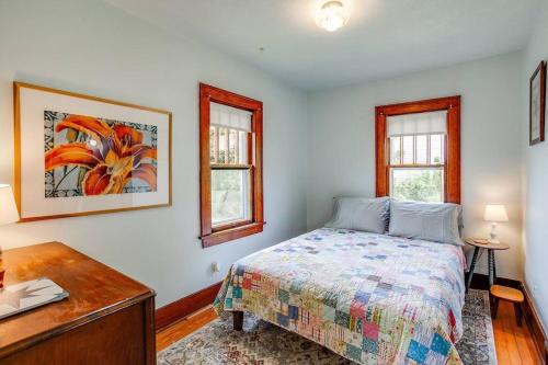 een slaapkamer met een bed, een bureau en 2 ramen bij Artist’s Vintage Home 5 mins from ND Campus in South Bend