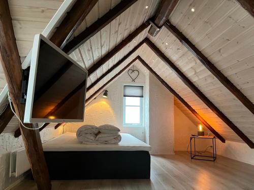 Zimmer mit einem TV auf einem Bett im Dachgeschoss in der Unterkunft Apartment downtown - Great View! in Klaksvík