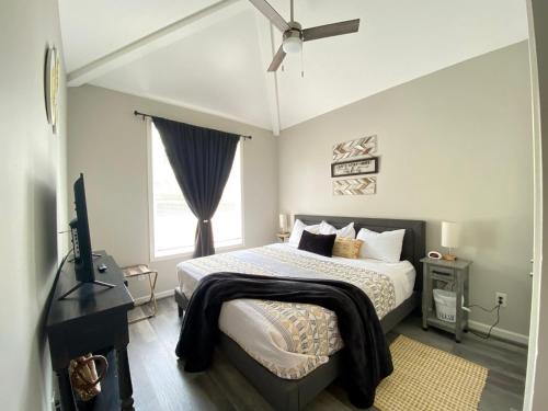 a bedroom with a bed and a ceiling fan at Cozy Corner - Family Beach Vacation Condo in Wilmington