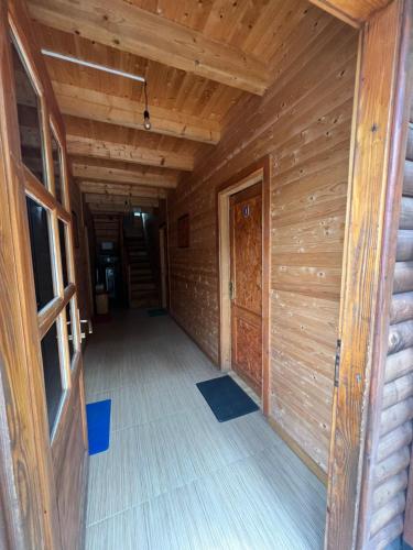 an empty hallway of a wooden cabin with a door at Vila Pepaj Razem in Razëm