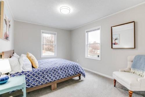 a bedroom with a bed and a chair and a mirror at Cozy Home w/ Sonos + Walking to Notre Dame in South Bend