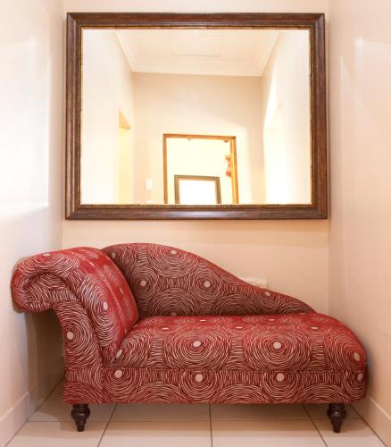 a red couch in a room with a mirror at Whispering Waters in Fort Nottingham