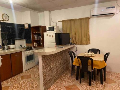 a kitchen with a table and a kitchen with a table and chairs at Los Tamarindos Posadamanabita in Portoviejo