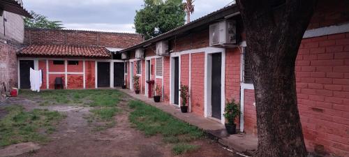 een rij rode bakstenen gebouwen met een boom bij Hostal San José in La Unión
