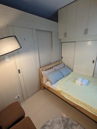 um pequeno quarto com uma cama com armários brancos em Staycation in Manila em Manila
