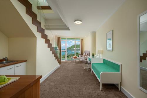 a kitchen and a living room with a stairway at Sunshine Resort Intime Sanya in Sanya