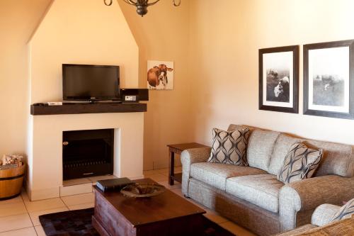 a living room with a couch and a fireplace at Whispering Waters in Fort Nottingham