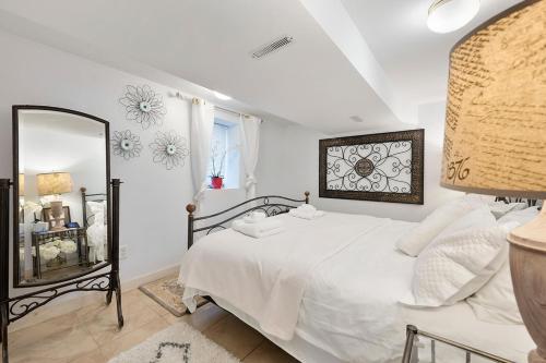 um quarto com uma cama branca e um espelho em AMAZING TRADITIONAL HOME SOUTH MINNEAPOLIS em Minneapolis