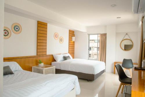 a hotel room with two beds and a chair at Alley & Pier in Bangkok