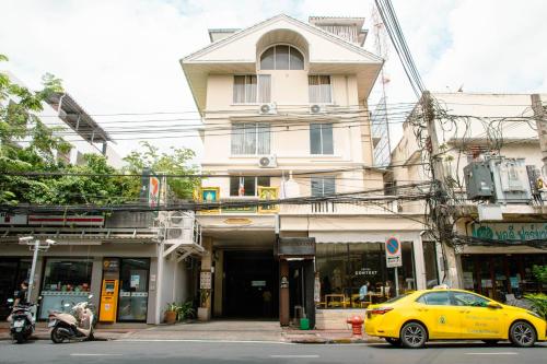 a yellow car parked in front of a building at Alley & Pier in Bangkok