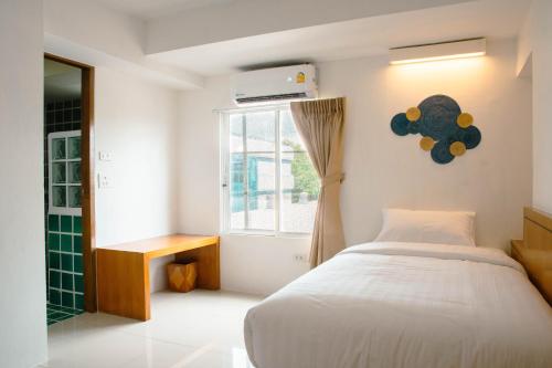 a bedroom with a bed and a window at Alley & Pier in Bangkok