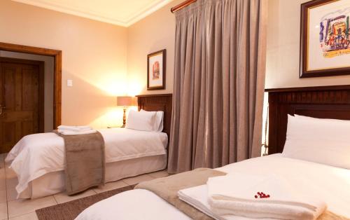 a hotel room with two beds and curtains at Whispering Waters in Fort Nottingham