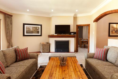 a living room with two couches and a coffee table at Whispering Waters in Fort Nottingham