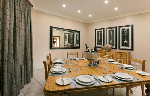 a dining room with a wooden table with plates at Whispering Waters in Fort Nottingham