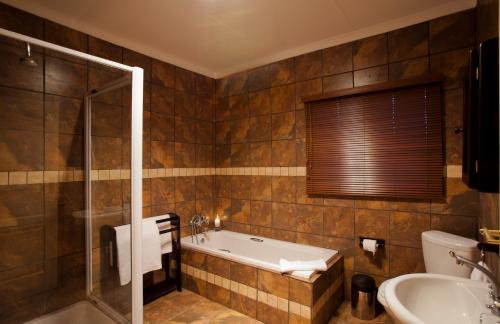 a bathroom with a tub and a sink at Whispering Waters in Fort Nottingham