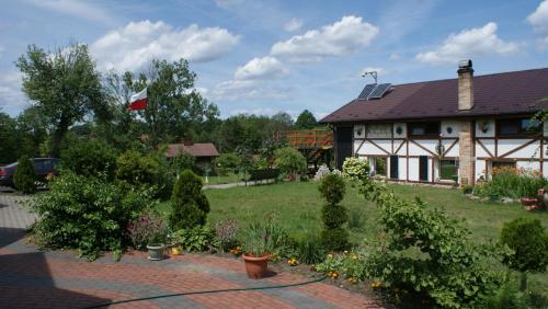 a house with a flag in the yard at Agroturystyka Makowscy in Trzcianka