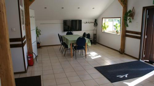 Habitación con mesa, sillas y TV. en Agroturystyka Makowscy, en Trzcianka