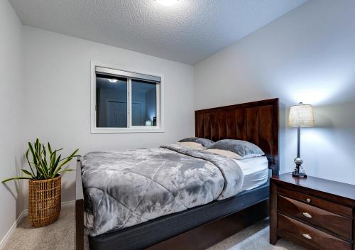 a bedroom with a bed and a dresser and a window at Stylish/4Bedroom/FreeParking/IndoorFirePlace in Calgary
