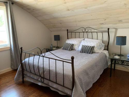 een slaapkamer met een groot bed met 2 kussens bij Escape, mins from Airport, EY Centre, Casino, Golf in Ottawa
