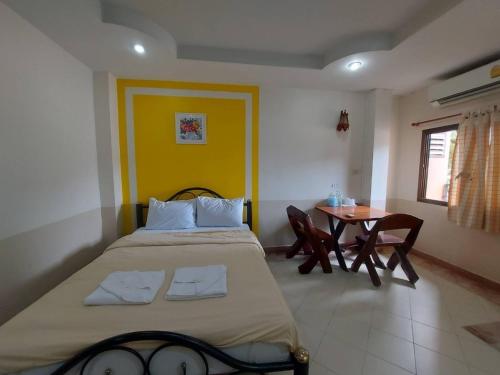 1 dormitorio con 1 cama grande y 1 mesa en Mongnon Hotel โรงแรมมองนอน อุดรธานี en Udon Thani