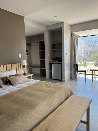 a bedroom with a large bed and a large window at La Morada in Purmamarca