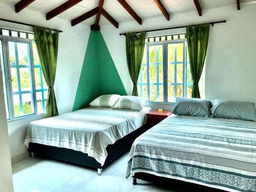 two beds sitting in a room with windows at Villa Lela, best way to chill & relax ! in Lemos