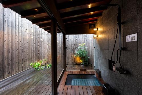 a plunge pool in the middle of a house with a wooden floor at Rinn Premium Nijo Castle North in Kyoto