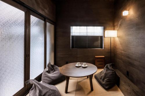 a small room with a table and chairs and a window at Rinn Premium Nijo Castle North in Kyoto