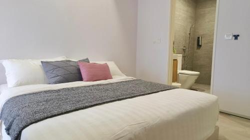 a bedroom with a large white bed with pillows at A1. The Ins @ Aurpra Place beside Pavillion Bukit Jalil in Kuala Lumpur