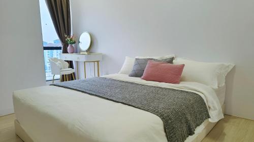 a bedroom with a white bed with a red pillow at A1. The Ins @ Aurpra Place beside Pavillion Bukit Jalil in Kuala Lumpur