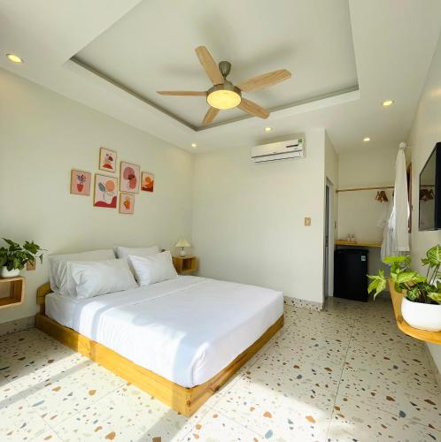 a bedroom with a bed with a ceiling fan at Sol Inn - Moc Chau in Mộc Châu