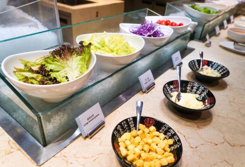 a display case with bowls of different types of food at WYNDHAM Foshan shunde in Shunde
