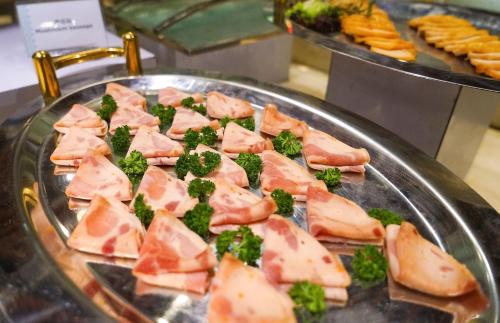a tray of food with broccoli and meat on it at WYNDHAM Foshan shunde in Shunde