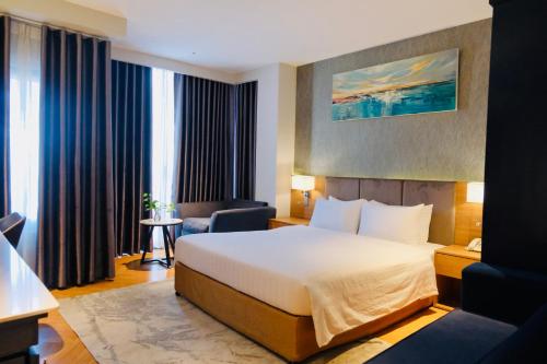 um quarto de hotel com uma cama e uma cadeira em Nicecy NganHa Hotel em Ho Chi Minh
