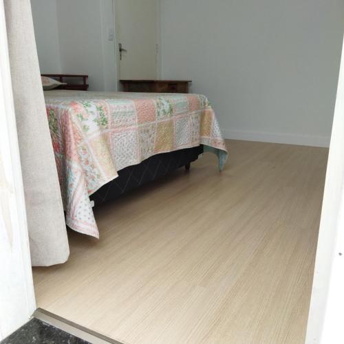 1 dormitorio con 1 cama y suelo de madera en Suíte com entrada Privativa en Barra Velha