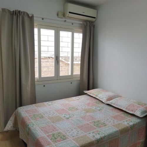1 dormitorio con cama y ventana en Suíte com entrada Privativa en Barra Velha