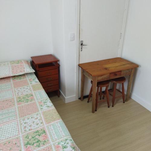1 dormitorio con escritorio, 1 cama y 1 mesa en Suíte com entrada Privativa en Barra Velha
